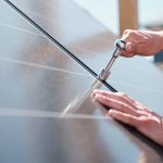 Hands of contemporary master with screw adjusting or installing solar panels